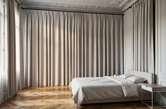 Chambre haussmannienne avec rideaux en lin gris colombe du plafond au sol fixés sur une tringle noire mate au ras du plafond
